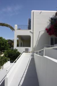 a white house with white stairs and a palm tree at Aktio Studios in Gavrion +11 photos