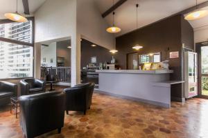 a restaurant with a bar with chairs and a counter at Le Charollais Motel Contact-Hôtel in Vitry-en-Charollais