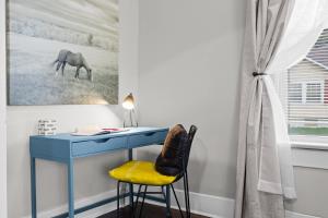 a blue desk with a chair and a horse painting at Walkable Historic District Riverview Escape in Jeffersonville +156 photos