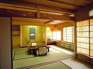 a room with a table in a room with windows at Charoku Bekkan in Miyazu