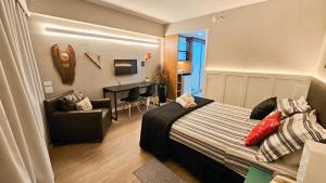 a bedroom with a bed and a living room at Lindo Studio com Jacuzzi e sacada a 50m Av Paulista in Sao Paulo