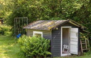 a small black shed with a chair in it at Nice Home In Vejby With Kitchen in Vejby +16 photos
