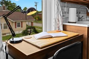 a desk with a lamp and an open book on a window at Riverview Escape in Walkable Historic District in Jeffersonville