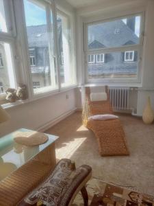 a living room with two chairs and two windows at Nr 9 Hübsche Suite mit Loggia in alte Villa mit Stadtblick und interessante Ausstattung Ohm Zimmer in Annaberg-Buchholz
