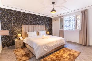 a bedroom with a large bed and a window at Maison soleil - Appartement pour famille in Marrakech +19 photos