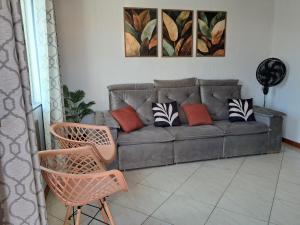 a living room with a couch and two chairs at Refúgio do Abricó - apto com ar e garagem in Rio das Ostras
