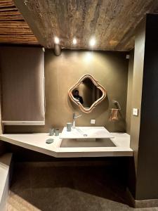 ein Badezimmer mit Waschbecken und Spiegel an der Wand in der Unterkunft Red Hill Lodge Purmamarca in Purmamarca + 33 Fotos