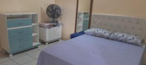 a bedroom with a bed and a dresser and a fan at Apartamento completo in Camocim