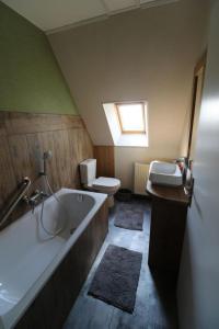 ein Badezimmer mit Badewanne, Toilette und Waschbecken in der Unterkunft Maison 8 personnes localisée au cœur de Sainte-Marie-du-Mont in Sainte-Marie-du-Mont + 16 Fotos