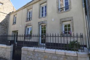 ein Haus mit einem Zaun davor in der Unterkunft Maison 8 personnes localisée au cœur de Sainte-Marie-du-Mont in Sainte-Marie-du-Mont