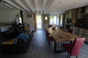 eine Küche und ein Esszimmer mit einem Holztisch und Stühlen in der Unterkunft Maison 8 personnes localisée au cœur de Sainte-Marie-du-Mont in Sainte-Marie-du-Mont