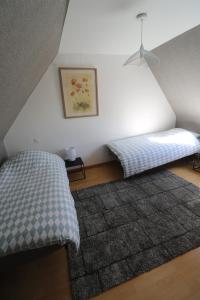 ein Schlafzimmer mit zwei Betten und einem Teppich in der Unterkunft Maison 8 personnes localisée au cœur de Sainte-Marie-du-Mont in Sainte-Marie-du-Mont