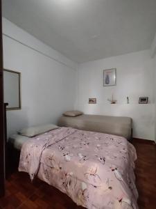a bedroom with a bed with a pink comforter at Granja Cafetalera Alegría in Mérida +25 photos