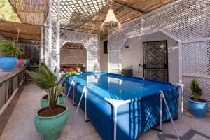 a group of blue tables in a room with plants at Maison soleil - Appartement pour famille in Marrakech