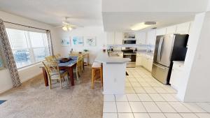 a kitchen and dining room with a table and a refrigerator at Islander Beach Resort 6007 in Fort Walton Beach