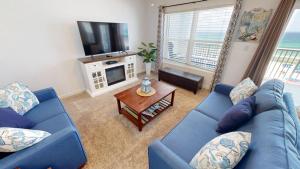 a living room with a blue couch and a tv at Islander Beach Resort 6007 in Fort Walton Beach
