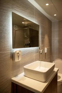 ein Badezimmer mit einem weißen Waschbecken und einem Spiegel in der Unterkunft Stay Hanyang - Foreigner only in Seoul