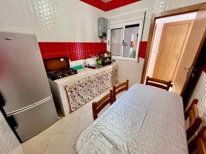 a small kitchen with a table and a refrigerator at Abdu house in Oulad Akkou