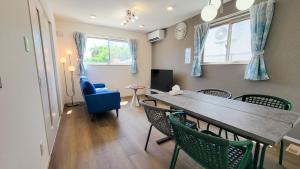 a living room with a dining room table and chairs at Klasse Villa Miyako in Miyako-jima