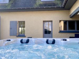 a bath tub sitting in front of a house at Villa élégante avec parc arboré, spa et équipements complets pour 14 pers. dans la campagne flamande - FR-1-510-8 in Estaires