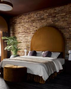 ストラトフォードにあるHotel Julieのレンガの壁のベッドルーム1室(大型ベッド1台付)