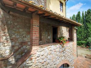 un edificio in pietra con una finestra e fiori di Apartment in a farmhouse with swimming pool a Mensanello