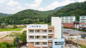a building with a mountain in the background at Gangneng badapunggeong Pension in Gangneung +6 photos