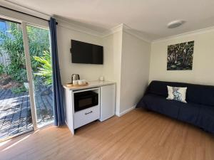 a living room with a couch and a flat screen tv at Copacabana Beach Cabin in Copacabana