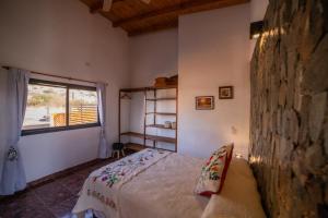 un dormitorio con una cama y una ventana en cabañas vistas de Cafayate, en Cafayate 108 fotos más