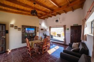 una sala de estar con una mesa y sillas en cabañas vistas de Cafayate, en Cafayate