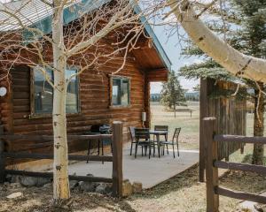 a log cabin with a table and chairs at Bar N Ranch in West Yellowstone