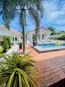 a house with a swimming pool and palm trees at Rooma Kichi Private Pool in Pantai Cenang