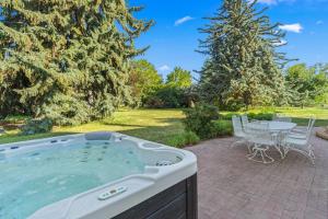 a hot tub on a patio with a table and chairs at Gardenview Estate Bed and Breakfast in Kettle Falls