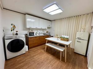 a small kitchen with a table and a white refrigerator at MISO Stay in Seoul +52 photos