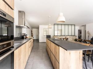 eine Küche mit Holzschränken und einer Arbeitsplatte in der Unterkunft Villa 125m² avec piscine chauffée, 3 chambres, terrasse à La Flotte - FR-1-835-30 in La Flotte