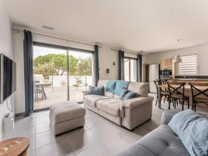ein Wohnzimmer mit Sofa und Tisch in der Unterkunft Villa 125m² avec piscine chauffée, 3 chambres, terrasse à La Flotte - FR-1-835-30 in La Flotte