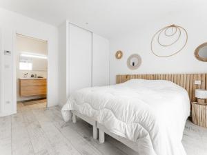 ein weißes Schlafzimmer mit einem großen Bett und einem Badezimmer in der Unterkunft Villa 125m² avec piscine chauffée, 3 chambres, terrasse à La Flotte - FR-1-835-30 in La Flotte + 25 Fotos