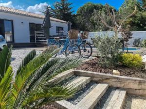 ein Garten mit zwei Fahrrädern, die neben einem Haus geparkt sind in der Unterkunft Villa 125m² avec piscine chauffée, 3 chambres, terrasse à La Flotte - FR-1-835-30 in La Flotte