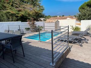 eine Terrasse mit einem Tisch und Stühlen sowie einem Pool in der Unterkunft Villa 125m² avec piscine chauffée, 3 chambres, terrasse à La Flotte - FR-1-835-30 in La Flotte