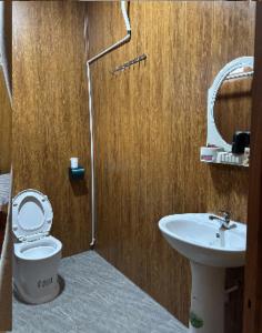 a bathroom with a toilet and a sink at Lam House's homestay Măng Đen in Kon Tum