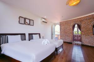 Ein Bett oder Betten in einem Zimmer der Unterkunft Ancient Garden Boutique Hoi An