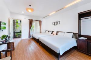 Ein Bett oder Betten in einem Zimmer der Unterkunft Ancient Garden Boutique Hoi An