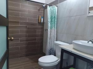 a bathroom with a toilet and a sink at Habitaciones Comodas in Manzanillo