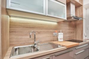 eine Küche mit einer Spüle aus Edelstahl und Holzwänden in der Unterkunft Apartments Tre Perle in Umag