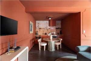 eine Küche mit orangefarbenen Wänden und einem Tisch mit Stühlen in der Unterkunft Hotel Julie in Stratford