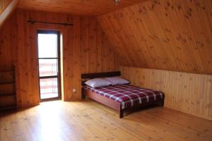a bedroom with a bed in a wooden room at Два дома на берегу Лимана in Vapnyarka