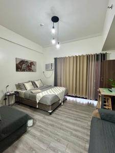 a bedroom with two beds and a couch at Amani Grand Citygate 308 in Davao City +11 photos