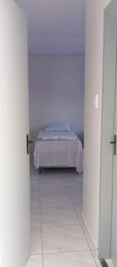 a bedroom with a bed in a white room at A M Hotel in São Luís