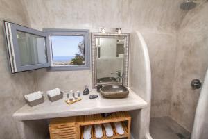 a bathroom with a sink and a mirror at Compass Villa in Oia