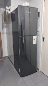 a large black refrigerator sitting in a room at Depto 1 ambiente in Mar del Plata